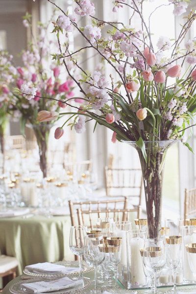 a vase filled with flowers sitting on top of a table next to glasses and plates