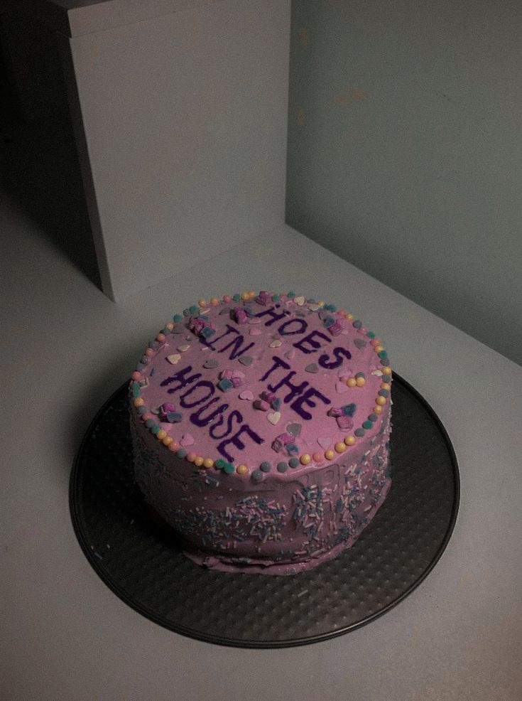 a birthday cake with writing on it sitting on top of a table next to a wall