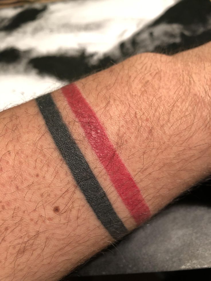 a man's arm with red, black and grey stripes on the left side