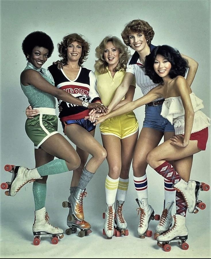 four women in short shorts and roller skates posing for a photo with their hands on each other's hips