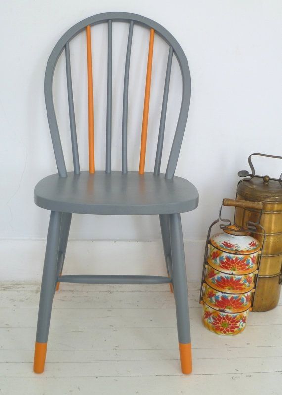 a grey and orange wooden chair next to a white wall