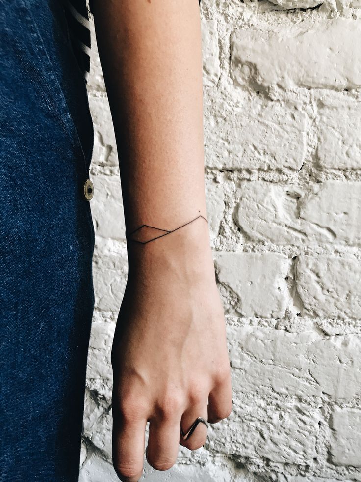 a person's arm with a small tattoo on the left side of their arm