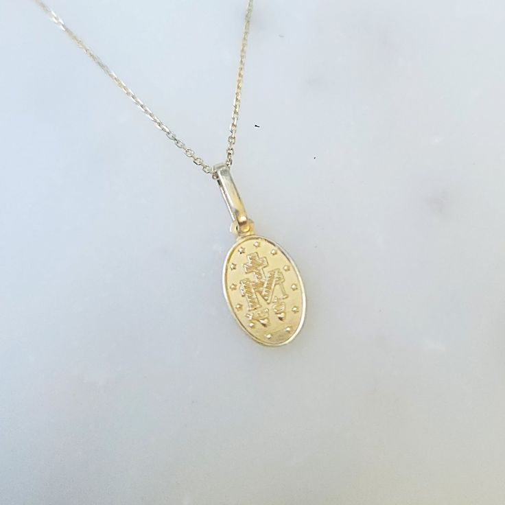 This stunning 14k Gold Miraculous Mary Medal is 18 inches in length, with a 16 inch jump ring for an adjustable fit. Made entirely of 14k gold, it is a small but magnificent piece. With the Medal of Our Lady of Graces, also known as the Miraculous Medal, one can carry a symbol of protection and divine grace. This Catholic jewelry serves as a reminder of Mary's eternal love and intercession for God's blessings. Wear it with love and trust, not as a mere lucky charm. Let it visibly show your devot 14k Yellow Gold Charm Necklace With Spring Ring Clasp, 14k Gold Oval Link Necklace Hallmarked, 14k White Gold Charm Necklace With Adjustable Chain, Yellow Gold Oval Link Charm Necklace For Gift, Oval Gold Plated Necklaces Stamped 14k, Oval Gold Plated Necklace Stamped 14k, Oval 14k Gold-filled Yellow Gold Necklaces, 14k Yellow Gold Tarnish Resistant Charm Necklace, 14k Yellow Gold Oval Link Charm Necklaces