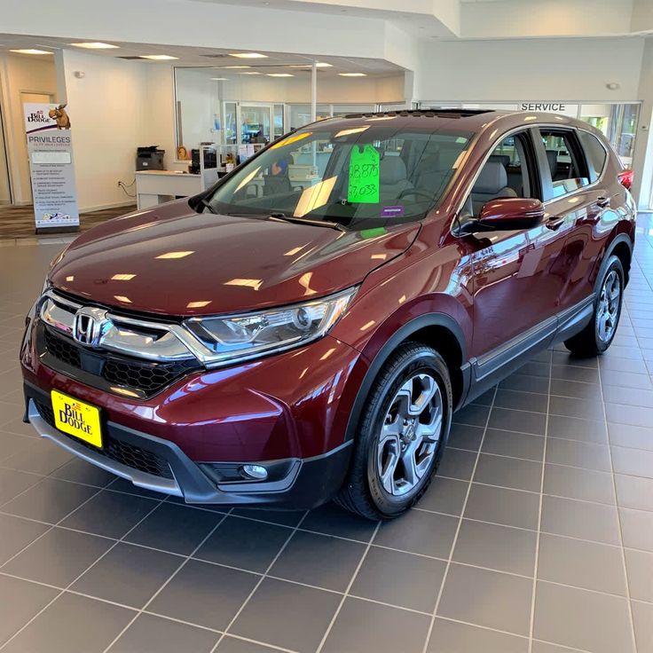 a red honda cr - v parked in a showroom