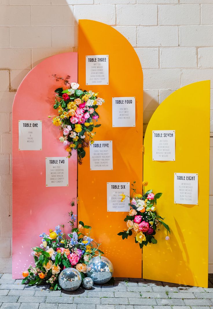 the diy wedding seating chart is on display in front of a wall with flowers