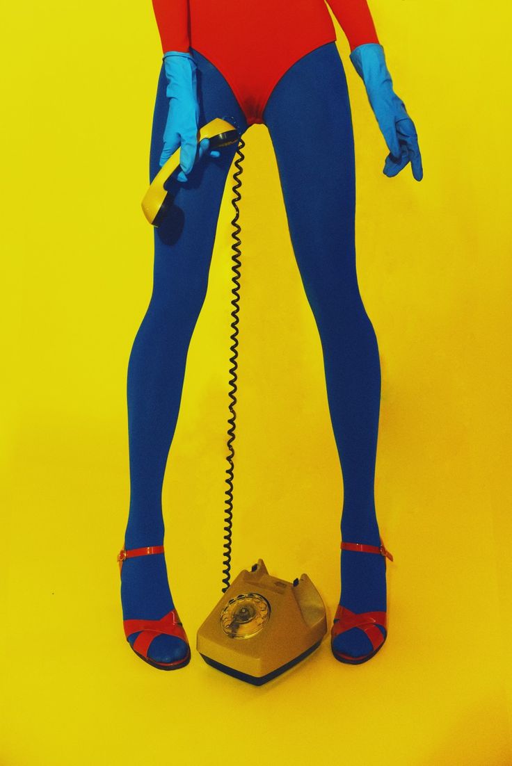 a woman in blue and red is holding a telephone