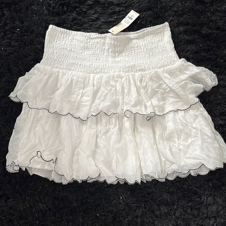 Size Large Never Worn New With Tag White Stretch Tiered Mini Skirt, White Tiered Skort For Spring, White Tiered Mini Skirt With Elastic Waistband, White Ruffled Skirt For Spring, White Stretch Skort With Ruffled Detail, White Ruffled Mini Bottoms, White Stretch Ruffled Skort, White Stretch Mini Skirt With Ruffles, White Stretch Skirt With Ruffles