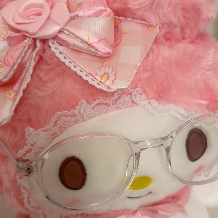 a pink teddy bear with glasses on it's face