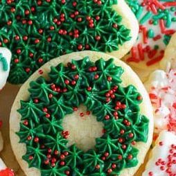 christmas cookies decorated with icing and sprinkles are arranged on a table