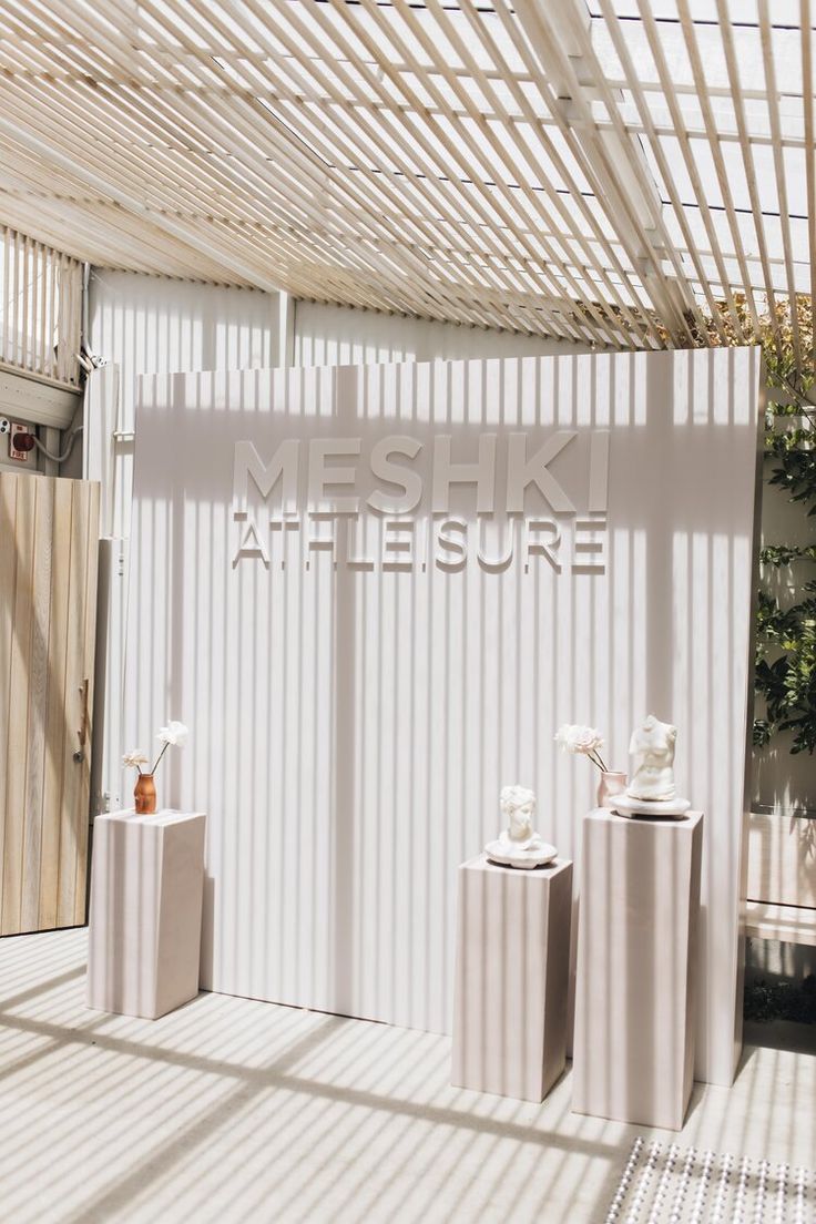 three white vases sitting in front of a sign that reads mesk atesure