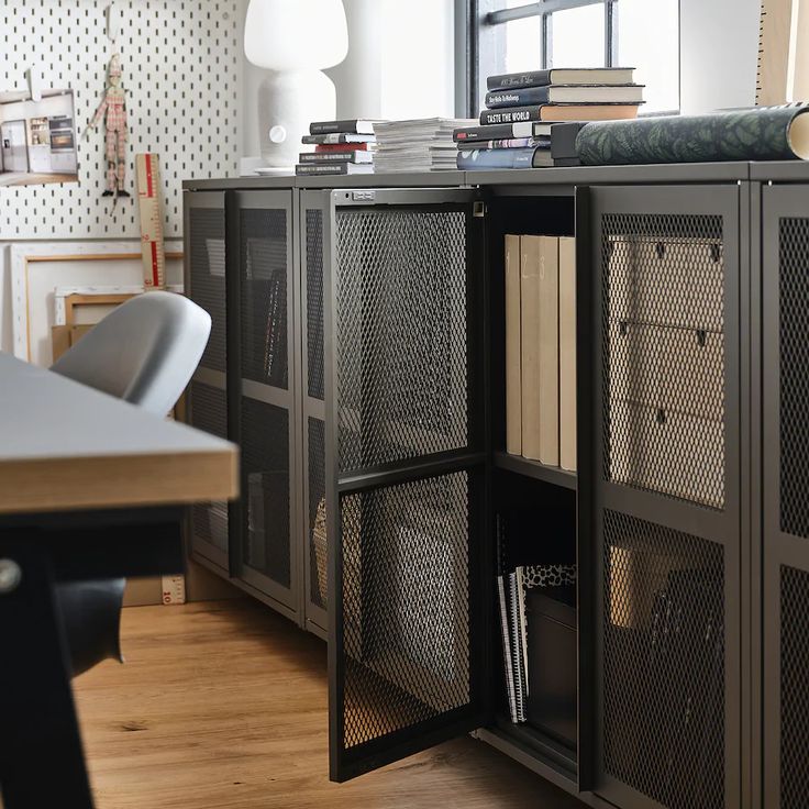 a bookcase with many books on top of it next to a table and chair