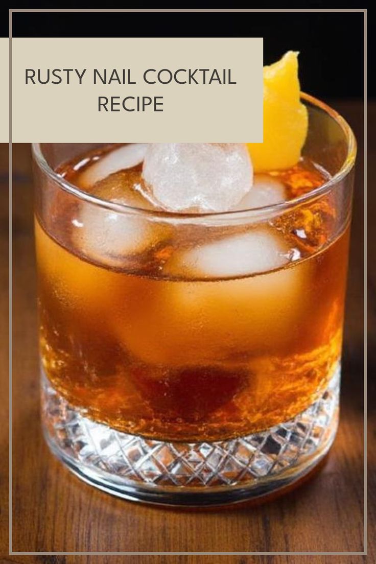 a glass filled with ice sitting on top of a wooden table