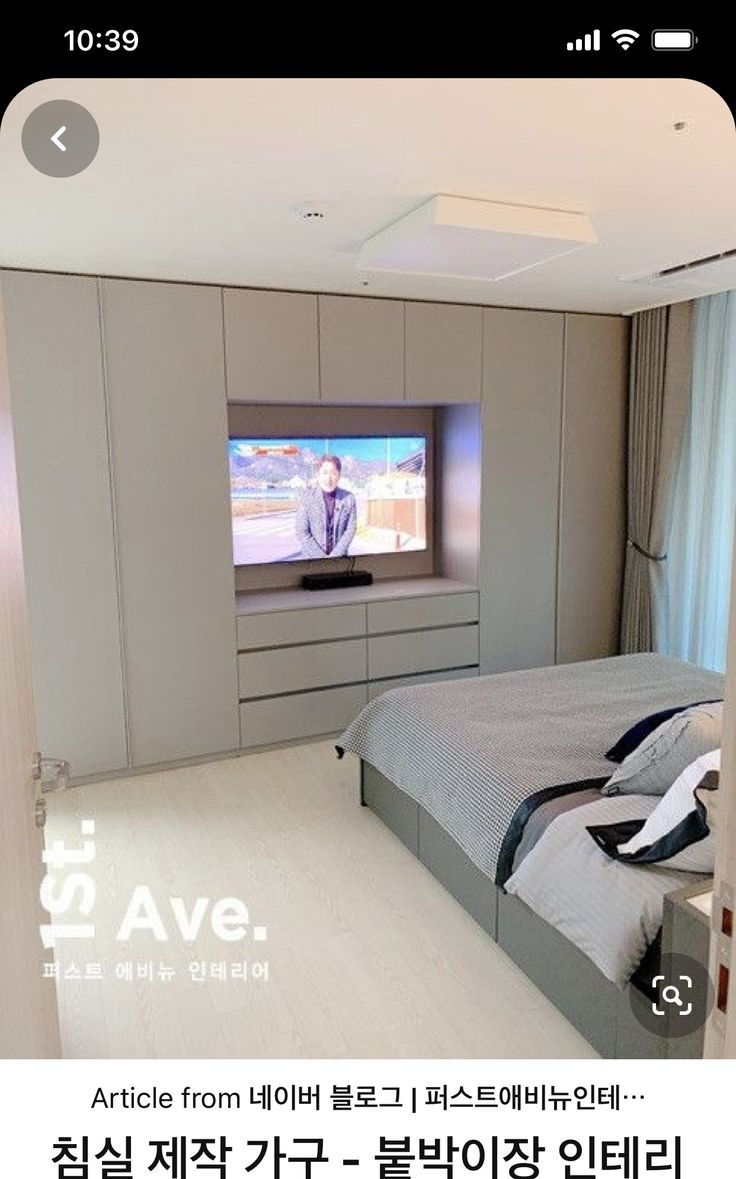 an image of a bedroom setting with tv in the middle and bed on the other side