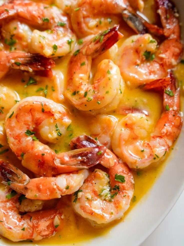 a white bowl filled with shrimp and sauce