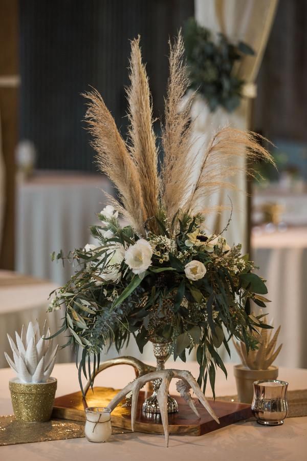 there is a vase with flowers and plants on the table