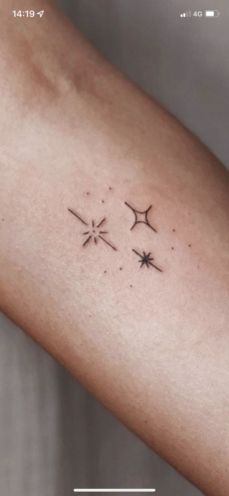 a woman's arm with three stars on it and the word love written in black ink