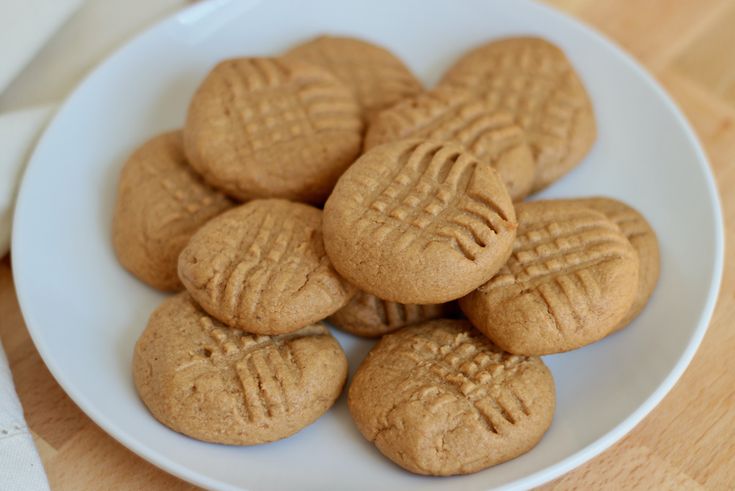 a white plate topped with cookies on top of a wooden table