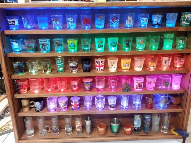 a shelf filled with lots of different colored glasses