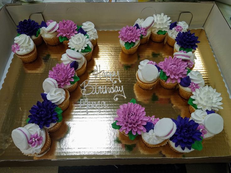 a birthday cake with purple and white flowers in the shape of an o - letter