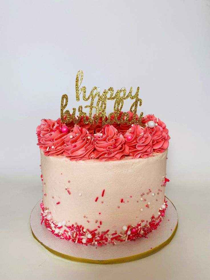 a birthday cake with pink and gold frosting