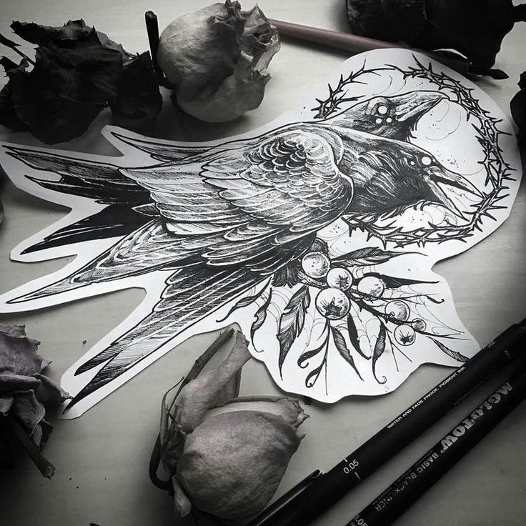 a black and white photo of a bird on a piece of paper next to some flowers