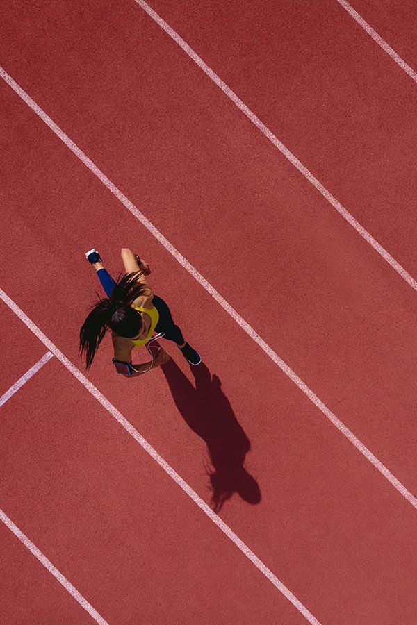 a woman standing on top of a red running track