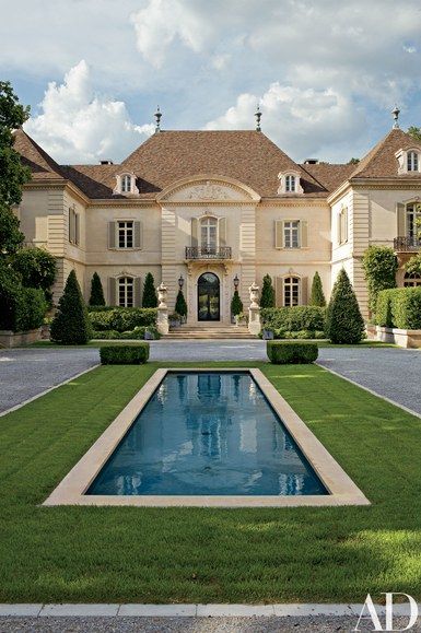 a large house with a pool in front of it and lots of grass on the ground