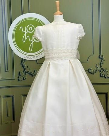 Margarita is an elegant and traditional first communion dress, it is made with off-white silk and has gorgeous lace details. The skirt is pleated and has details throughout. The appliqué is removable. The dress has covered buttons for closure, and strings to form a bow. Made in Spain Does not include crinoline Dry Clean Final sale, no exchanges nor returns are available Elegant A-line Confirmation Dress, Fitted Dress With Pleated Bodice For First Communion, White First Communion Dress With Pleated Bodice, White Pleated Bodice Dress For First Communion, Classic Dresses With Fitted Bodice For First Communion, Classic White Dress With Lace Bodice, Classic Lace Bodice Dress For First Communion, Elegant Cream First Communion Dress With Lace Bodice, Elegant Confirmation Dress With Lace Bodice