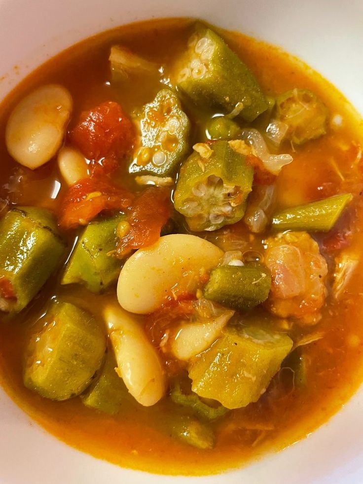 a white bowl filled with vegetable soup on top of a table