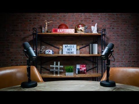 two brown leather chairs sitting in front of a wooden table with books on top of it