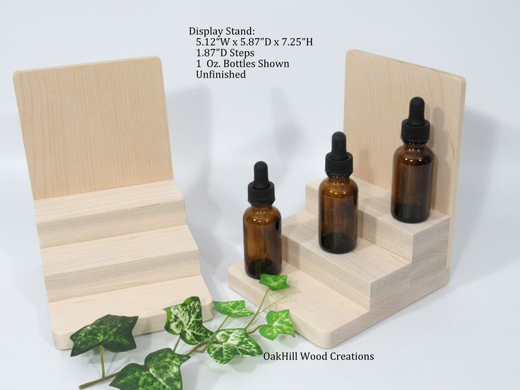 three bottles are sitting next to each other in front of a wooden stand with ivy leaves