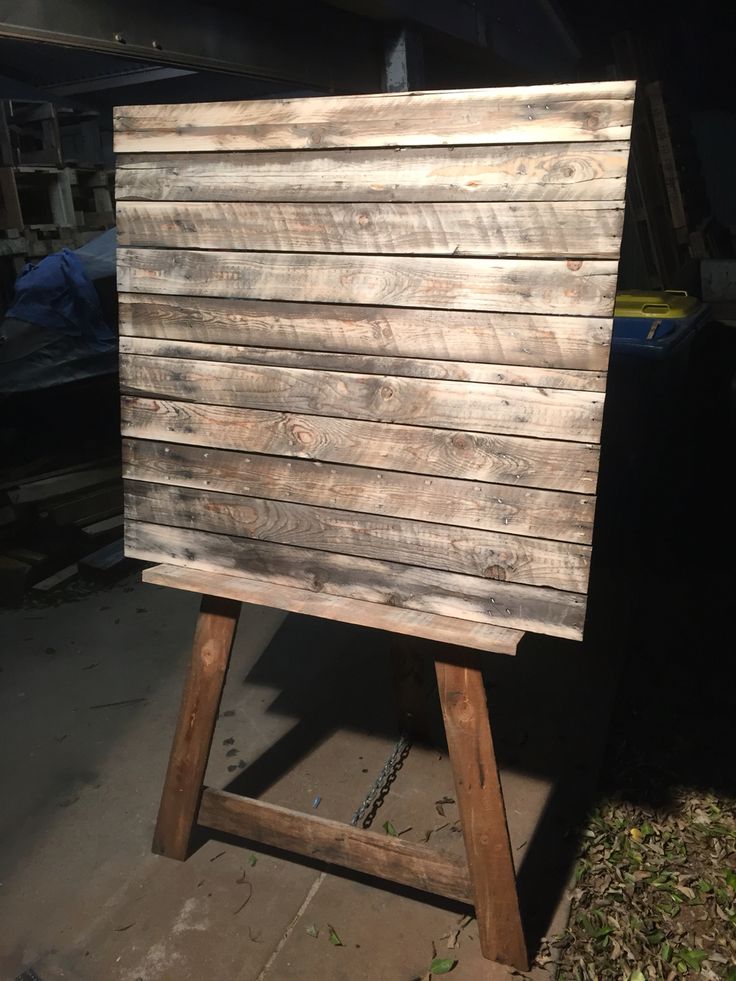 a wooden sign sitting on top of a wooden easel