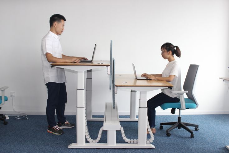 two people sitting at desks using laptop computers