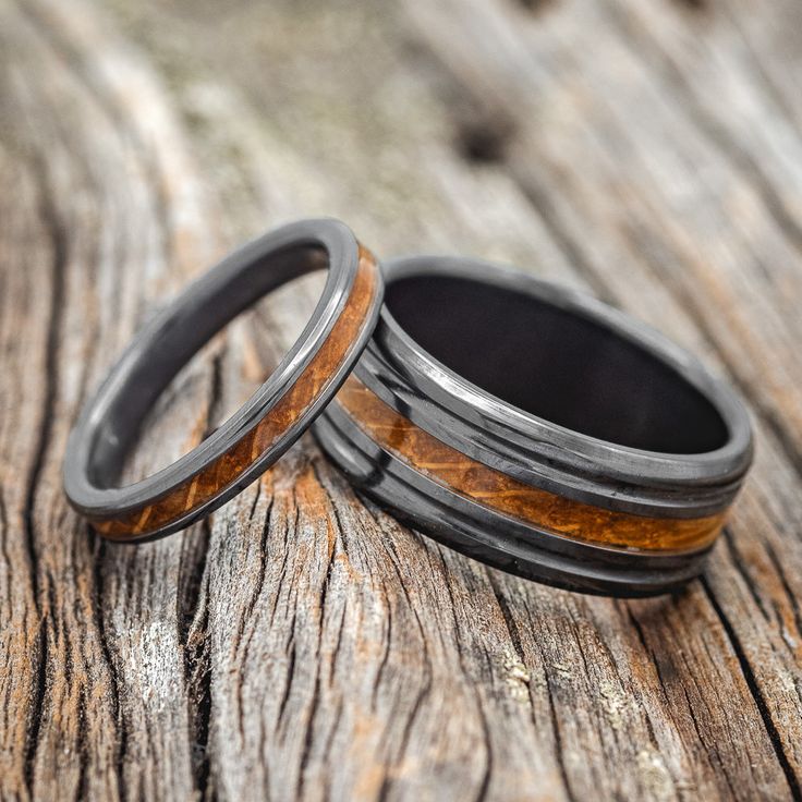 two wedding bands with wood inlays on top of each other