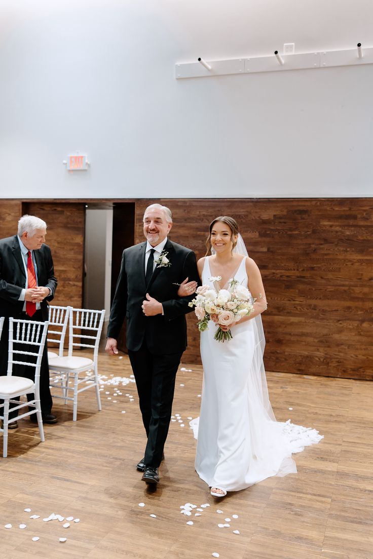 a bride and groom walking down the aisle at their wedding ceremony in an empty room