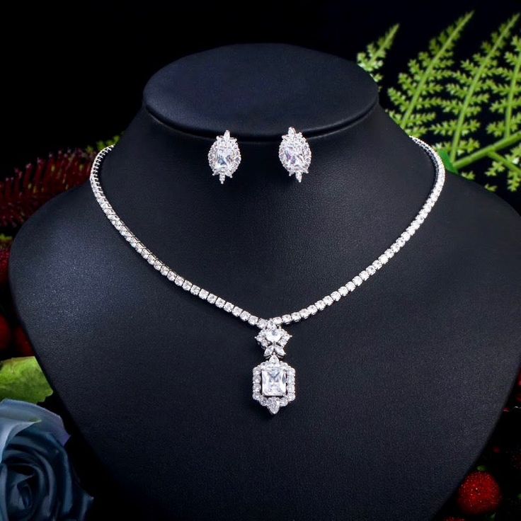 A beautiful two-piece bridal jewelry set with an elegant geometric vibe! Adorned with intricately faceted cubic zirconia that capture the light from every angle with a perfectly translucent appeal, the pieces are platinum plated for a flawless finish which enhances the intricate detailing and conveys a modern take on old elegance. Necklace: 17.5" (approx. 44.5) long, with a secure fold-over closure. Length of the pendant is 1.3" (approx. 3.3cm). Earrings: measure 0.75" (approx. 1.9cm) and come w Silver Wedding Jewelry, Bridal Jewelry Set, Yellow Jewelry, Crystal Jewelry Sets, Party Necklace, Necklace Sets, Cz Necklace, Stone Material, Wedding Bridal Jewellery