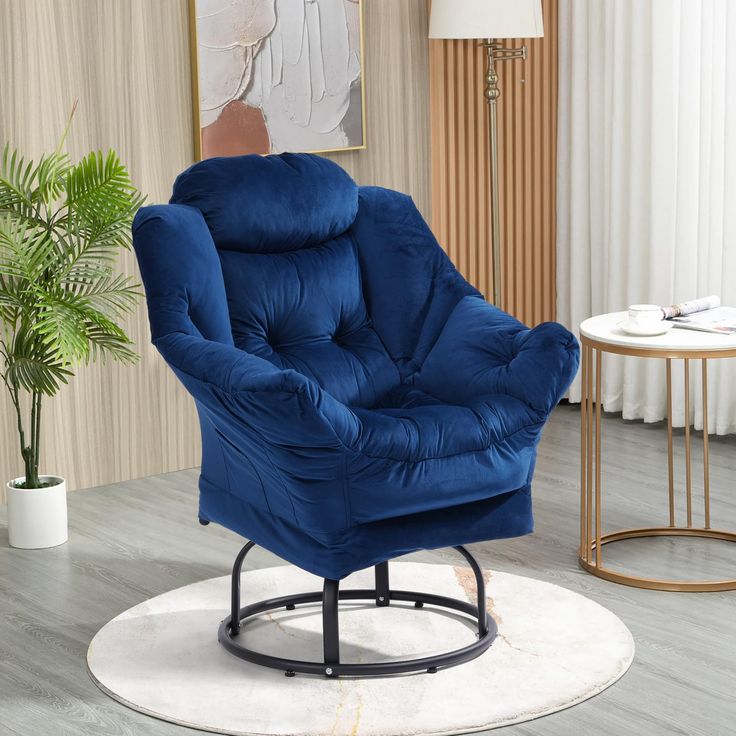 a blue chair sitting on top of a white rug in a living room next to a potted plant