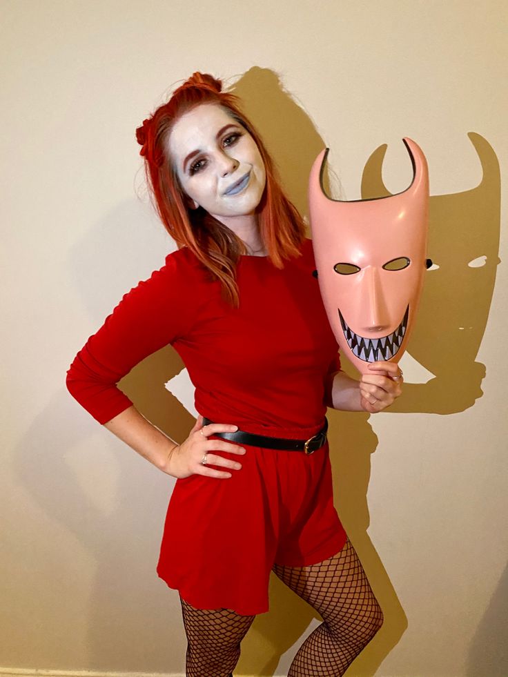 a woman in red is holding a mask