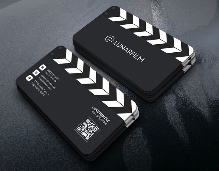 two black and white business cards sitting on top of a table