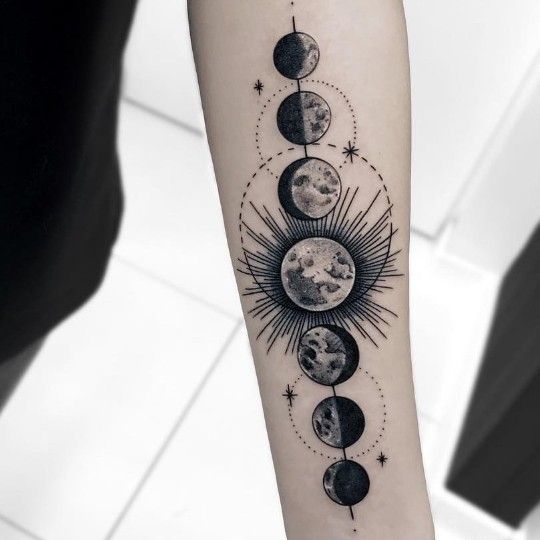 a woman's arm with phases of the moon and sun tattoo on her forearm