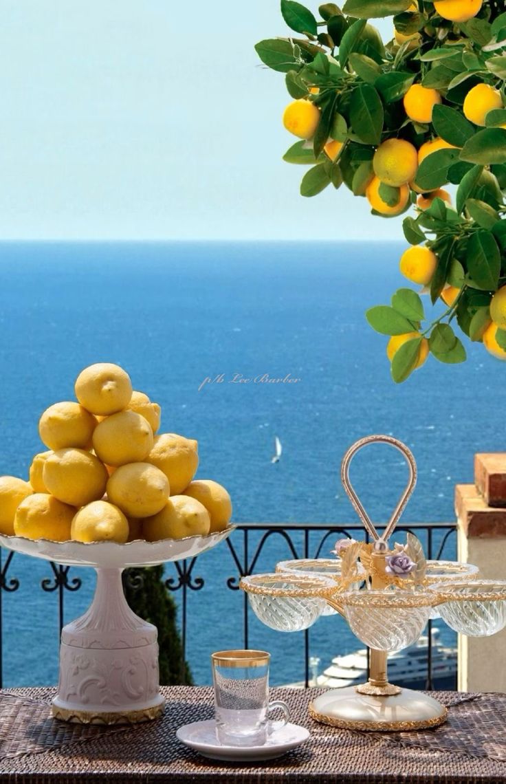 lemons are piled on top of each other in front of an ocean view table