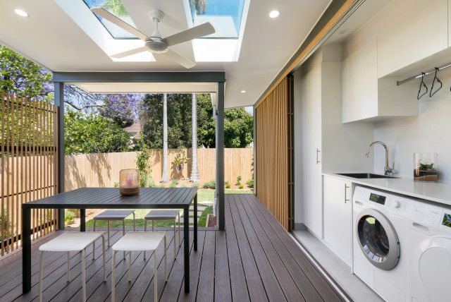 an outdoor kitchen and dining area with wood flooring