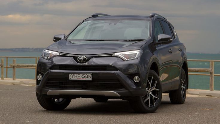 a grey toyota rav parked on the side of the road next to the ocean