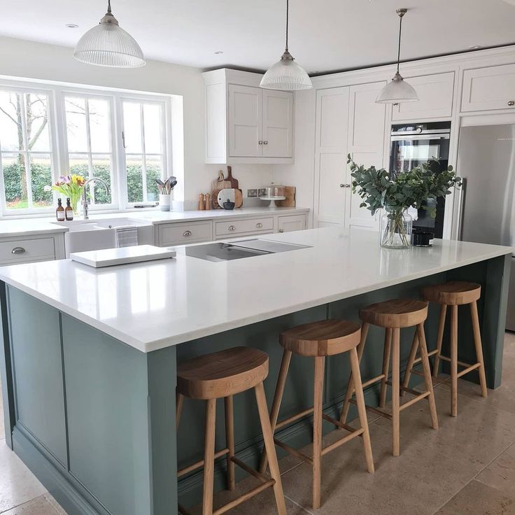 a kitchen island with four stools in front of it