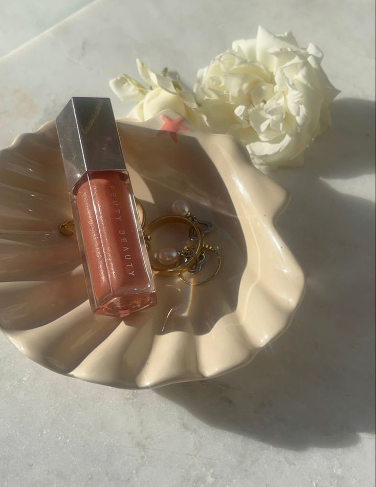 Fenty lip gloss in the shade fenty glow Fenty Gloss Aesthetic, Lip Gloss Shoot Ideas, Fenty Lipgloss Aesthetic, Fenty Glow Lipgloss, Fenty Beauty Lip Gloss Fenty Glow, Fenty Lip Gloss Aesthetic, Fenty Beauty Lip Gloss Aesthetic, Fenty Aesthetic, Lipgloss Photoshoot Ideas