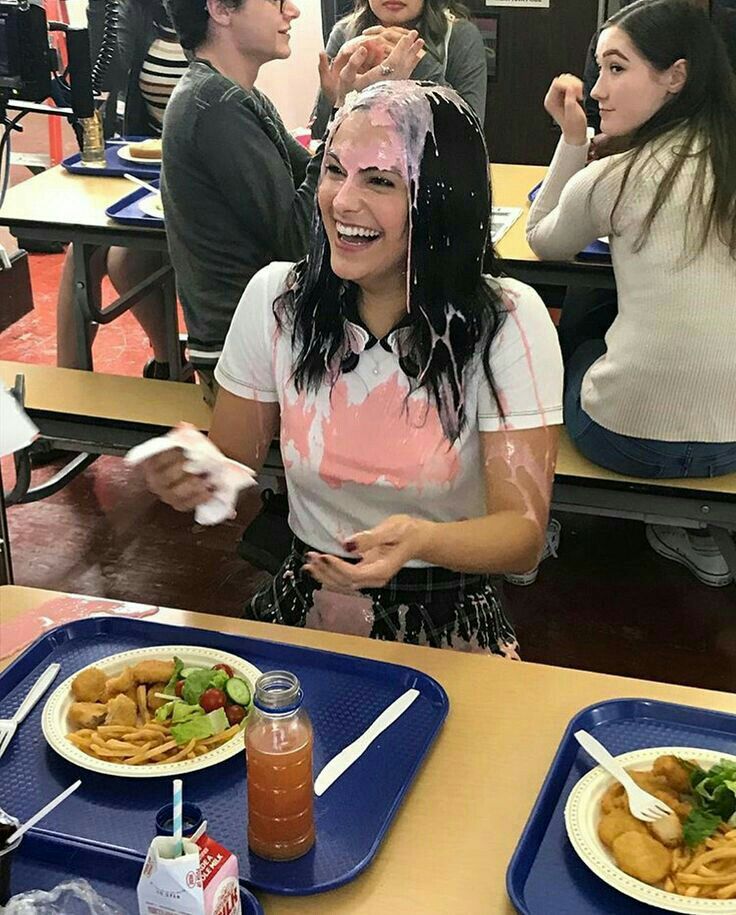 a woman sitting at a table covered in food