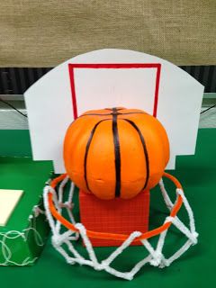 an orange basketball sitting on top of a white net next to a green tablecloth