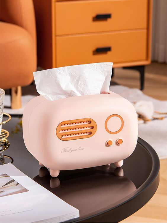 a pink toaster sitting on top of a coffee table next to a glass cup