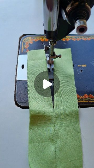 the sewing machine is working on the green fabric that has been sewn in it