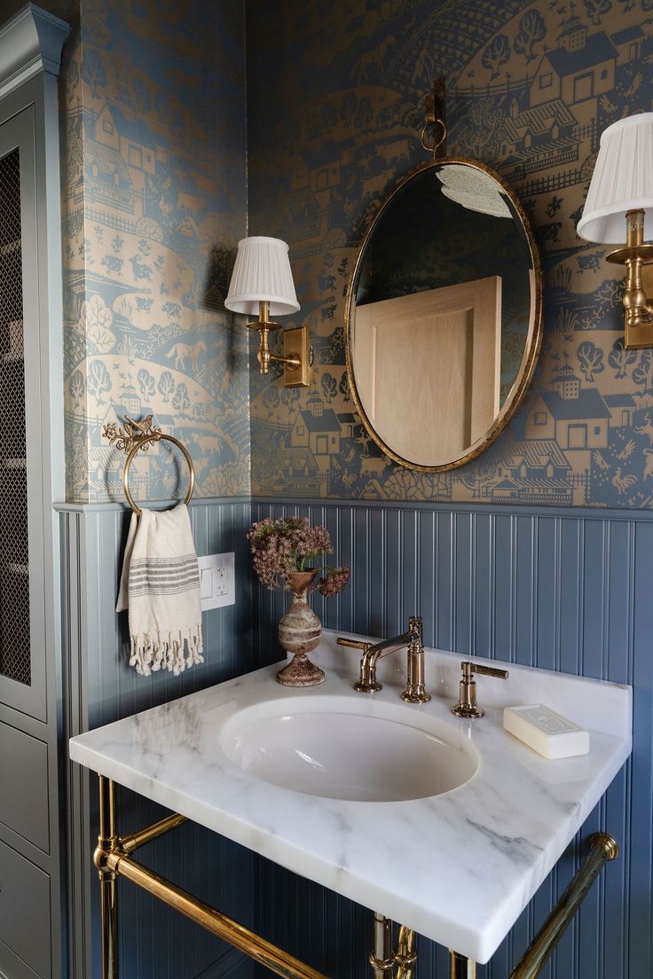 a white sink sitting under a bathroom mirror next to a wall mounted faucet